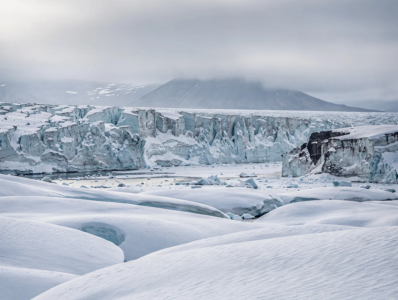 Vast blue glacial ice formations under soft arctic light