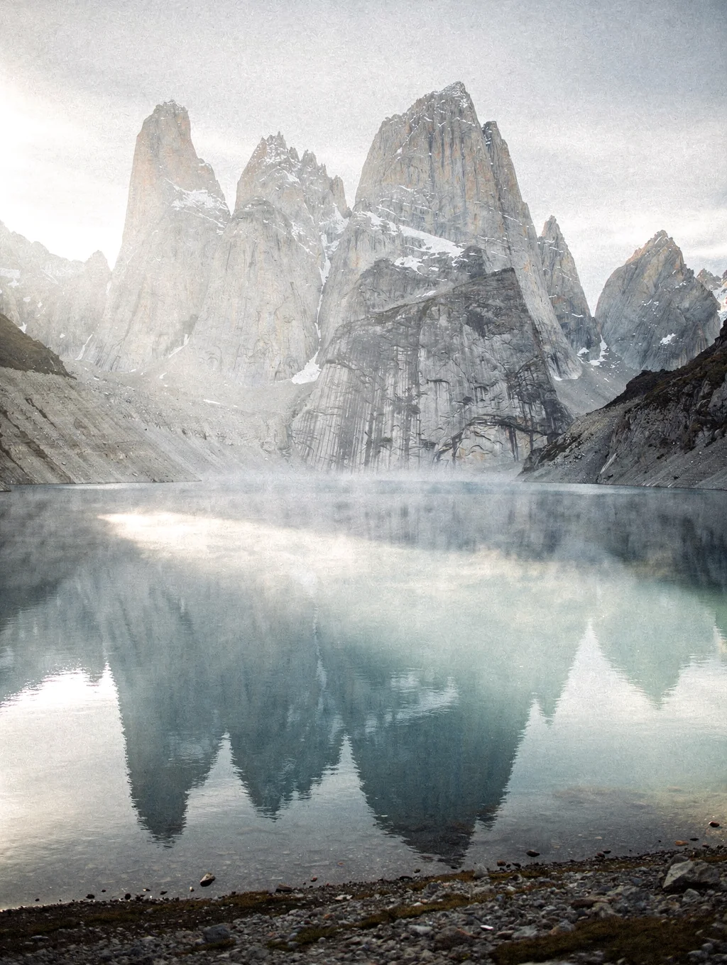 Reflective alpine lake beneath towering granite spires